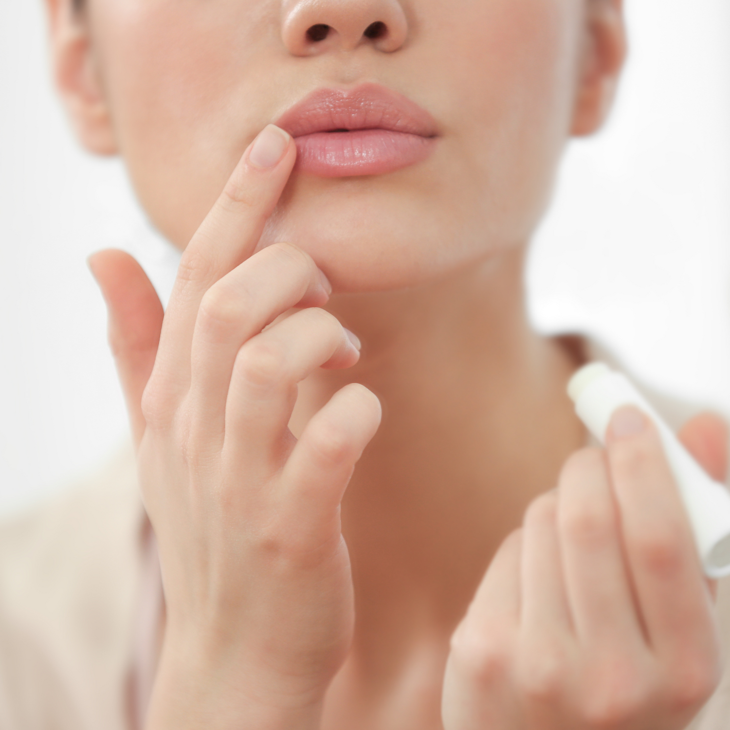 Frau trägt Lippenpflege auf die Lippen auf