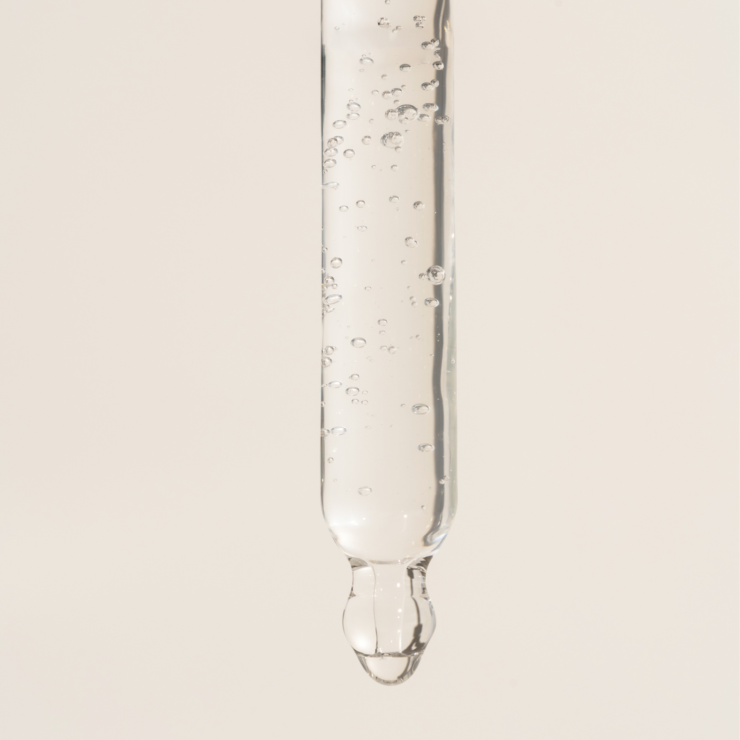Pipette vor hellem Hintergrund mit Serum tropf herunter
