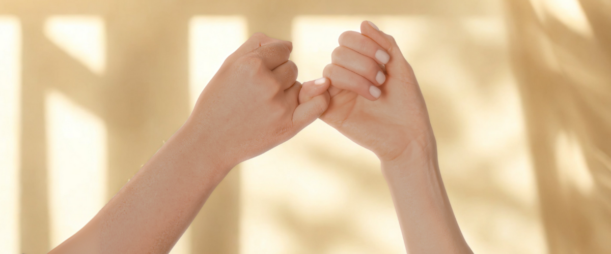 Pinky Promise, zwei Hände die sich mit dem kleinen Finger ein versprechen geben.
