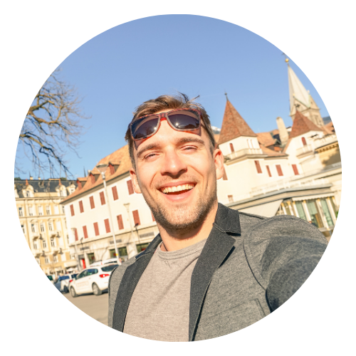 Mann Anfang dreißig steht in einer Deutschen Stadt und mach ein lächelndes Selfie